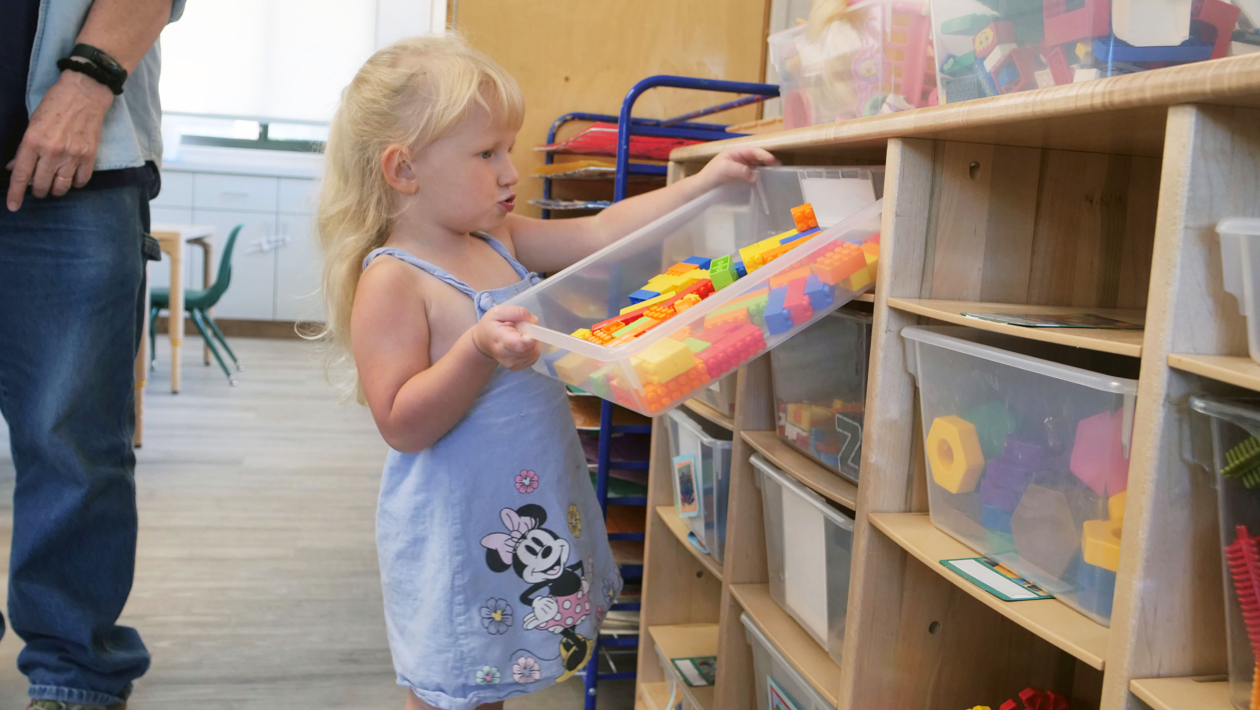 child putting away blocks