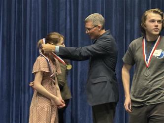 Jeremy Hunt places medal around students neck